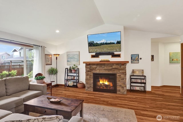 living room featuring a stone fireplace, wood finished floors, recessed lighting, and vaulted ceiling