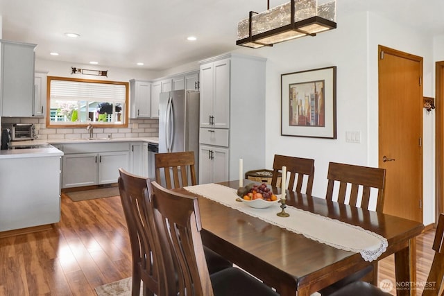 dining space with a toaster, recessed lighting, and wood finished floors