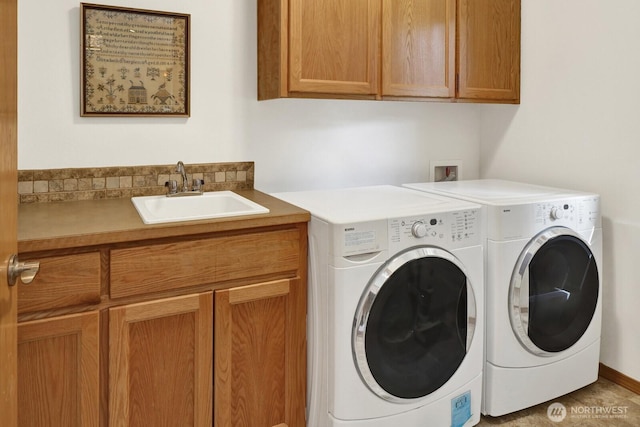laundry area with independent washer and dryer, a sink, and cabinet space
