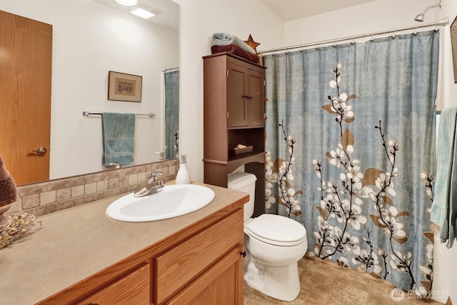 full bath with curtained shower, vanity, and toilet