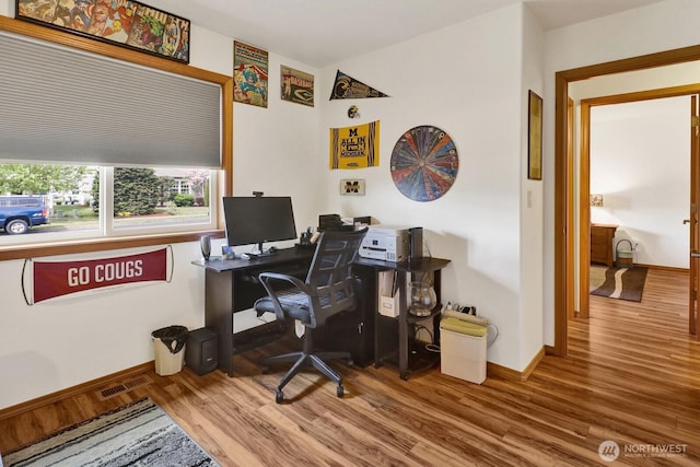 office featuring baseboards, visible vents, and wood finished floors