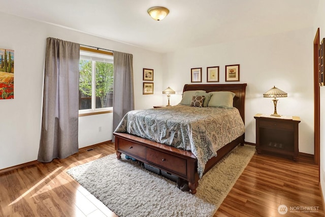 bedroom with baseboards and wood finished floors