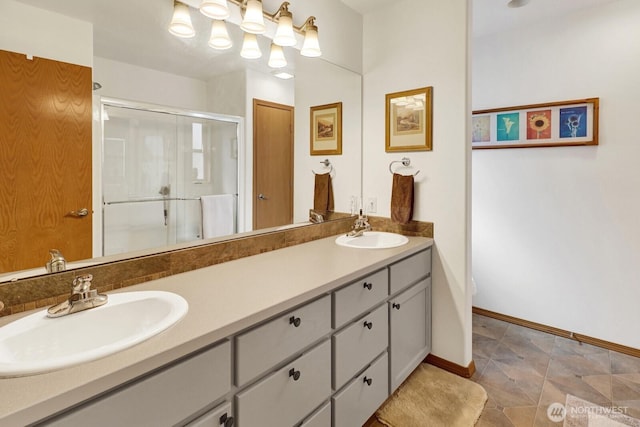 full bathroom featuring a sink, double vanity, baseboards, and a shower stall