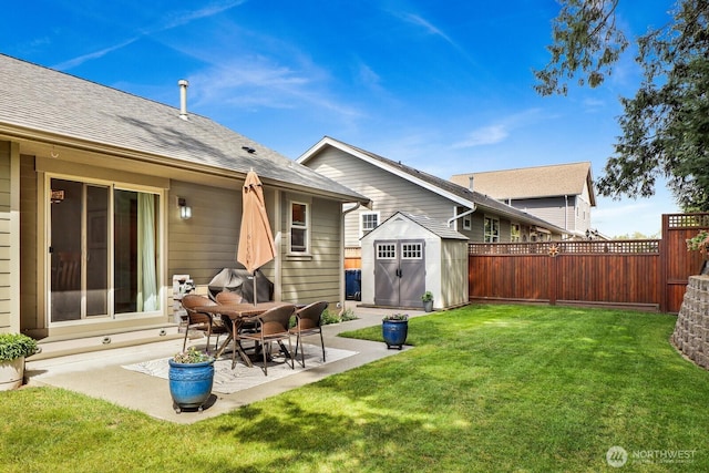 back of house with a patio, a storage unit, a lawn, an outdoor structure, and a fenced backyard