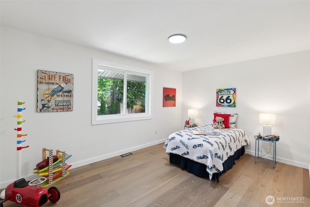 bedroom with wood finished floors and baseboards