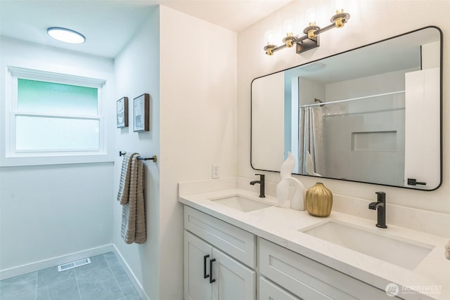 full bathroom featuring baseboards, a shower with shower curtain, and double vanity