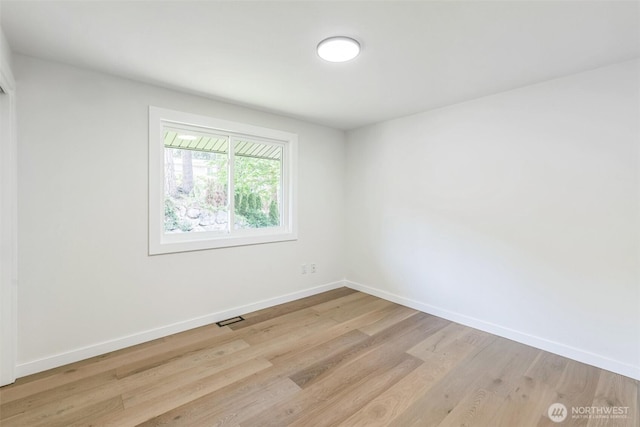 unfurnished room featuring baseboards and light wood-type flooring