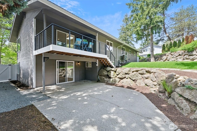 back of property with a patio area, a sunroom, and a gate