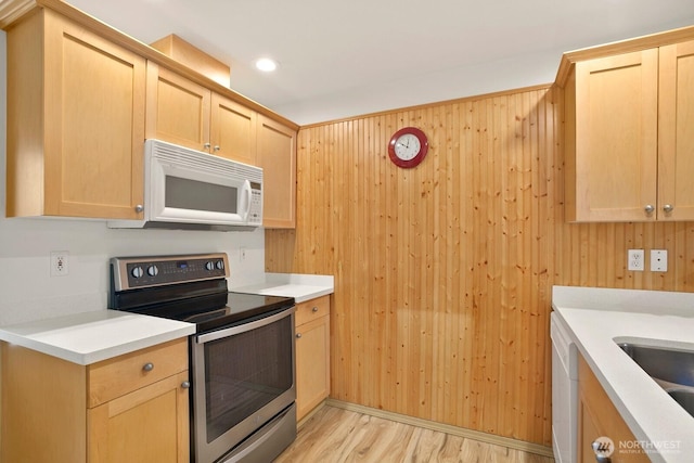 1140 N 92nd Unit B, Seattle, WA 98103 - kitchen featuring white microwave, electric stove, light brown cabinetry, light wood-style flooring, and wooden walls