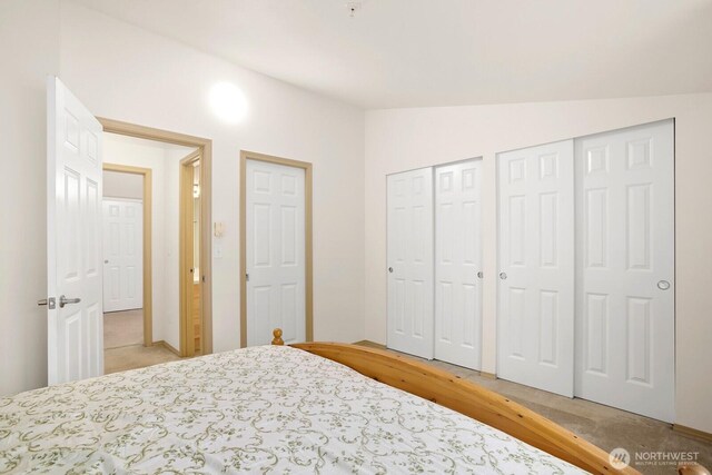1140 N 92nd Unit B, Seattle, WA 98103 - bedroom with multiple closets, vaulted ceiling, and light wood finished floors