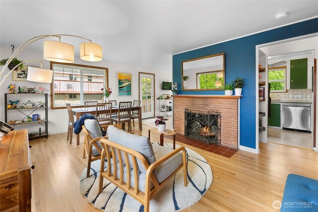 living room with wood finished floors and a brick fireplace