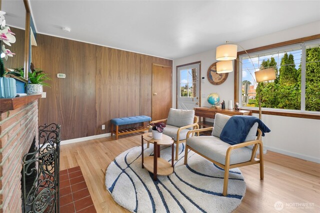 sitting room featuring wood finished floors, baseboards, and wood walls
