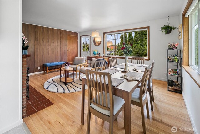 dining space featuring light wood-style flooring and baseboards
