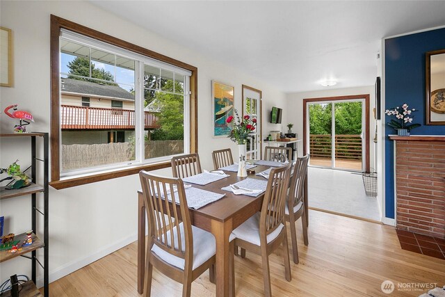 dining area featuring light wood-style flooring and baseboards