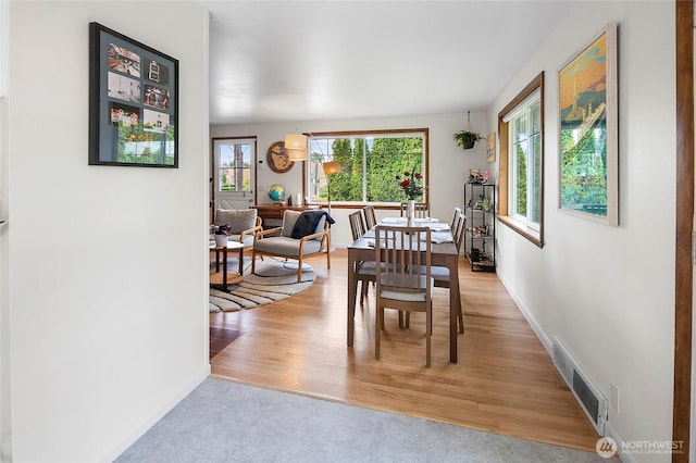 dining area featuring light wood-type flooring and baseboards