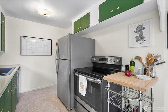 kitchen with stainless steel appliances, green cabinetry, baseboards, and light countertops