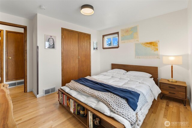 bedroom featuring a closet, light wood-type flooring, and baseboards