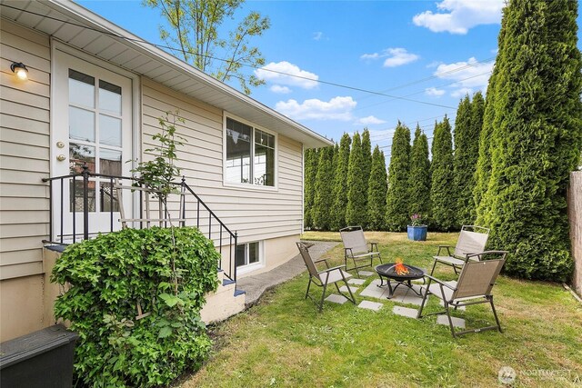 view of green lawn with a fire pit