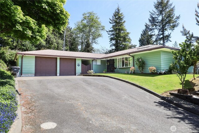 ranch-style house with a garage, a front lawn, and asphalt driveway