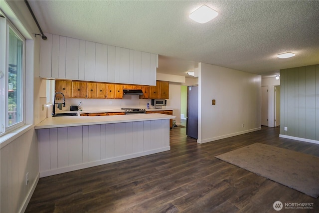 1234 Friedlander Dr, Aberdeen, WA 98520 - kitchen featuring a sink, under cabinet range hood, a textured ceiling, light countertops, and appliances with stainless steel finishes