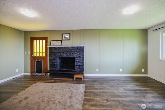 1234 Friedlander Dr, Aberdeen, WA 98520 - unfurnished living room with a textured ceiling, a stone fireplace, wood finished floors, and baseboards