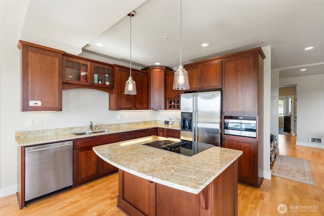 1215 Lawrence St Unit 201, Port Townsend, WA 98368 - kitchen with appliances with stainless steel finishes, a sink, light wood-style flooring, light stone countertops, and recessed lighting
