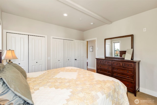 1215 Lawrence St Unit 201, Port Townsend, WA 98368 - bedroom featuring multiple closets, baseboards, light colored carpet, and beam ceiling
