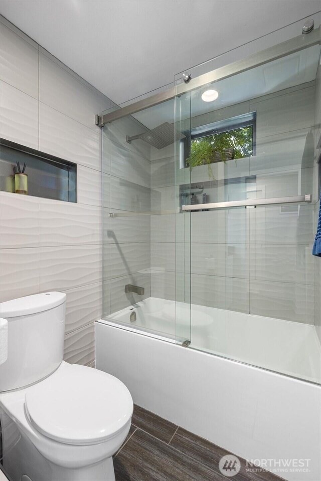 full bathroom featuring enclosed tub / shower combo and toilet