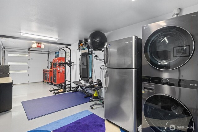 clothes washing area featuring stacked washer and clothes dryer and a garage