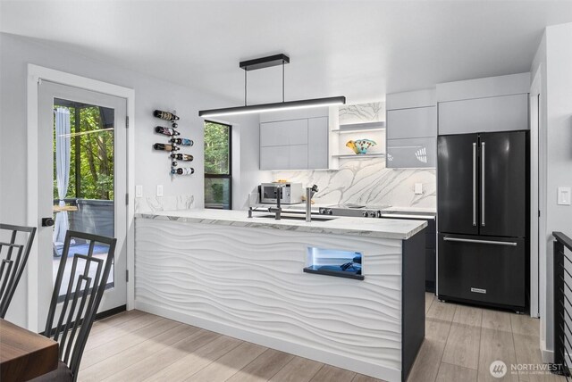 kitchen featuring high end refrigerator, modern cabinets, healthy amount of natural light, and open shelves