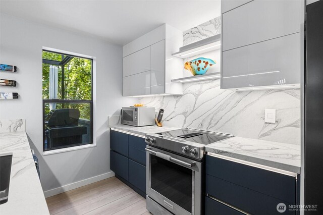 kitchen featuring stainless steel electric stove, open shelves, light wood-type flooring, decorative backsplash, and baseboards