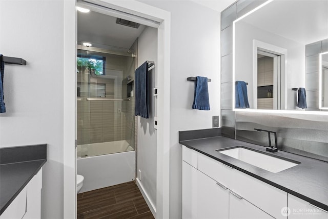 1495 Mukilteo Speedway, Mukilteo, WA 98275 - bathroom featuring vanity, toilet, wood finished floors, enclosed tub / shower combo, and baseboards