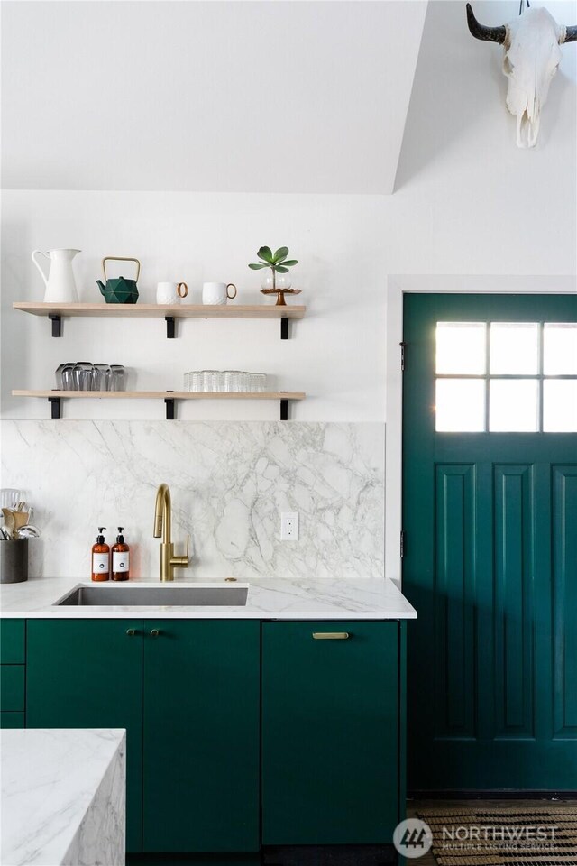 bar area with tasteful backsplash, a sink, and vaulted ceiling