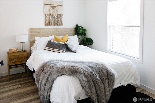 bedroom with wood finished floors and baseboards