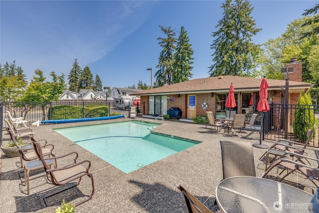 view of swimming pool with a patio and fence