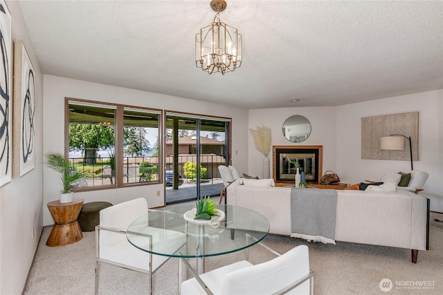 dining space featuring a textured ceiling, a chandelier, and carpet floors