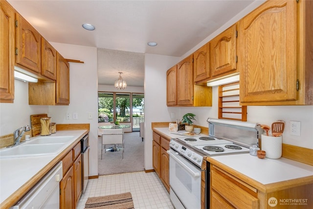 kitchen featuring white appliances, a sink, light countertops, a chandelier, and recessed lighting