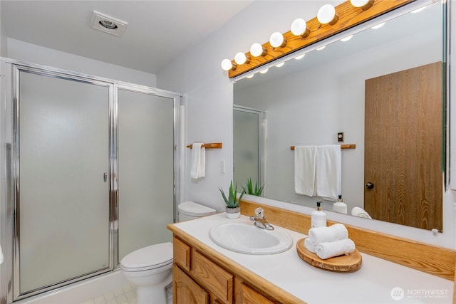 bathroom featuring a shower stall, vanity, toilet, and tile patterned flooring