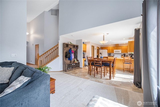 9006 190th St E, Puyallup, WA 98375 - living room with light carpet, stairway, and a high ceiling