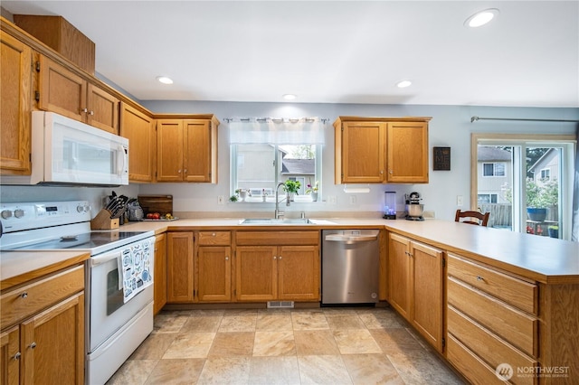 9006 190th St E, Puyallup, WA 98375 - kitchen featuring white appliances, a sink, a peninsula, plenty of natural light, and recessed lighting