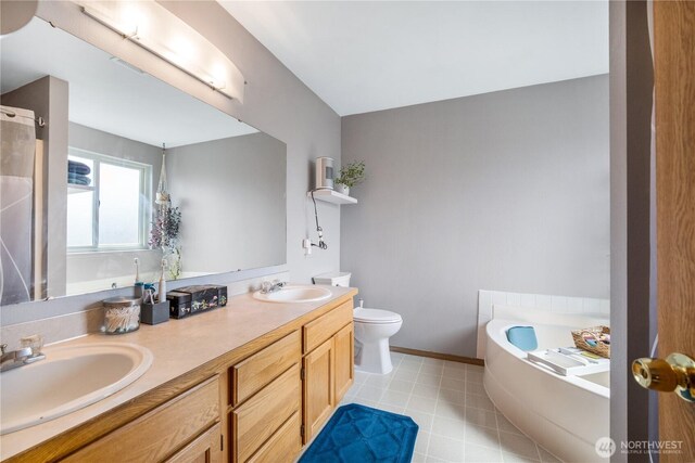 9006 190th St E, Puyallup, WA 98375 - full bath with a garden tub, toilet, double vanity, and baseboards