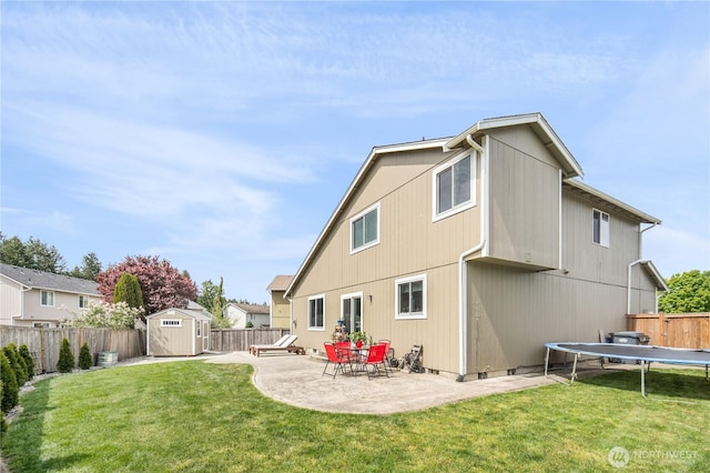 9006 190th St E, Puyallup, WA 98375 - rear view of house featuring a storage shed, a trampoline, a patio, and an outdoor structure