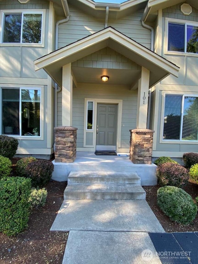 view of exterior entry featuring covered porch