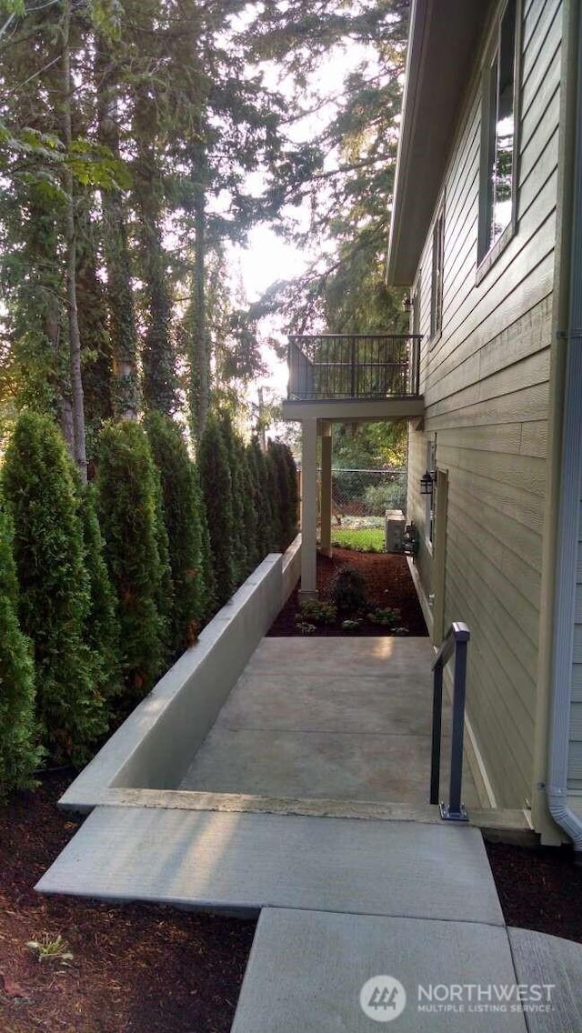 view of property exterior featuring cooling unit and a balcony