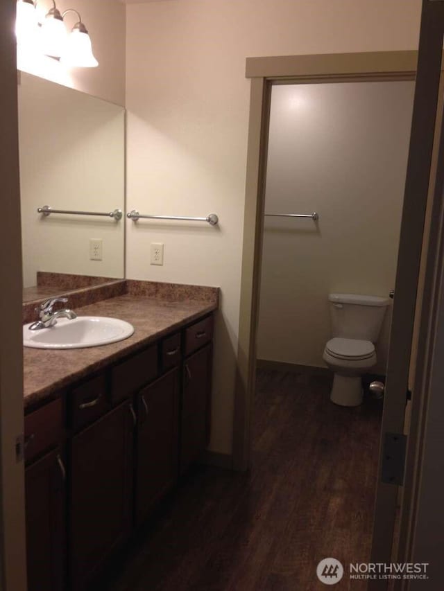 bathroom with vanity, toilet, and wood finished floors