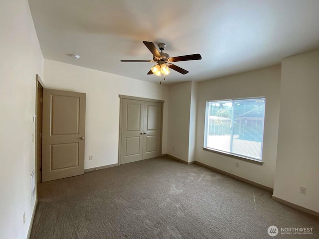 unfurnished bedroom with baseboards, ceiling fan, and carpet