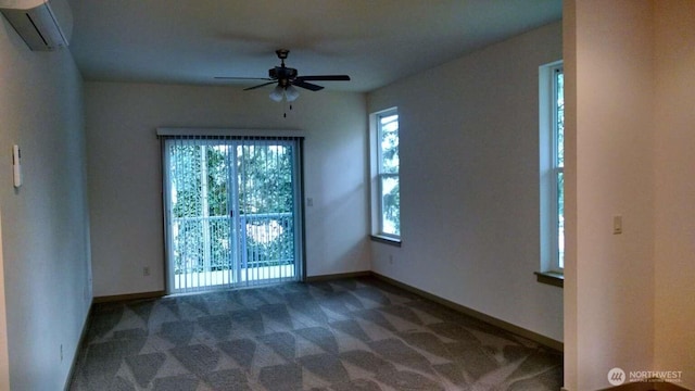 carpeted spare room featuring ceiling fan, a wall mounted air conditioner, and baseboards