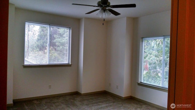 empty room with light colored carpet, baseboards, ceiling fan, and a healthy amount of sunlight
