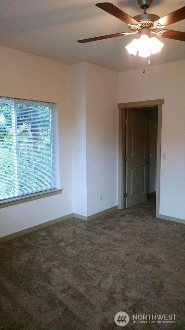 carpeted spare room with baseboards and ceiling fan