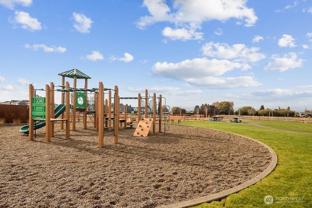 community play area featuring fence and a lawn
